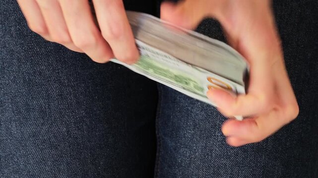 Close up of woman hands counting stack of hundred dollar bills