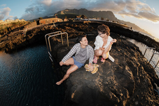 Friends enjoying sunset at natural volcanic pools