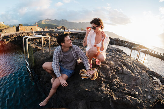 Couple relaxing at natural pools during golden hour sunset