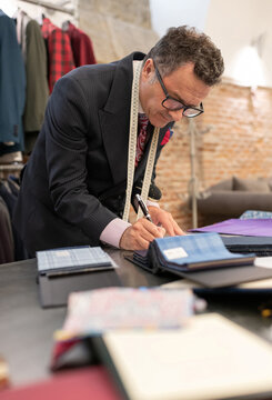 Dressmaker creating sketches near fabric samples
