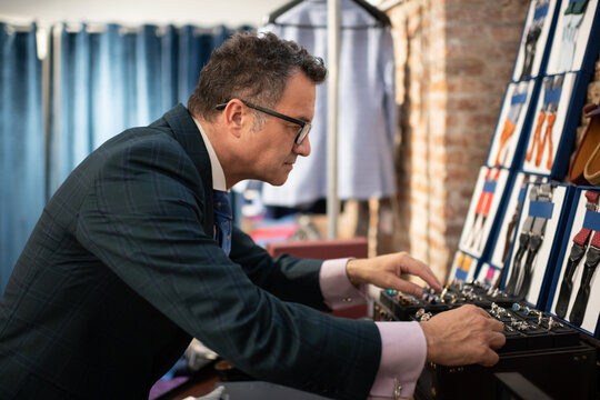 Mature dressmaker choosing accessories in studio