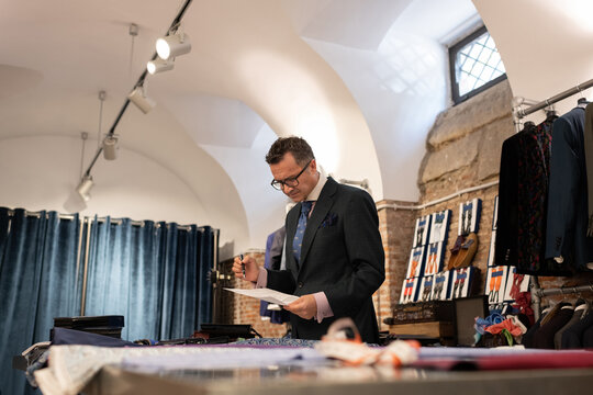Senior fashion designer man inspecting sketch