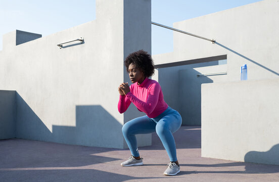 Black female athlete squatting