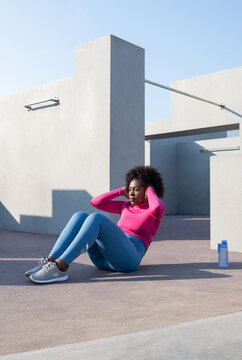 Black female athlete doing abdominal crunches