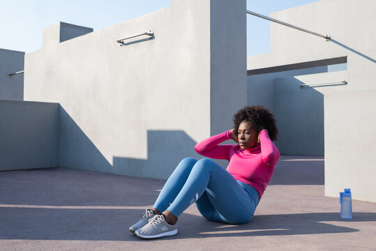 Black sportswoman doing abs exercise