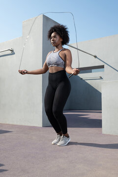 Black female athlete jumping with rope