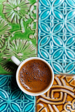 Cup of Turkish coffee on colorful ceramic tile table