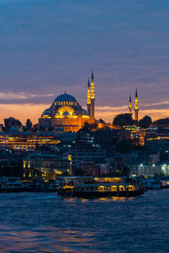 Illuminated mosque and ferry at night in Istanbul