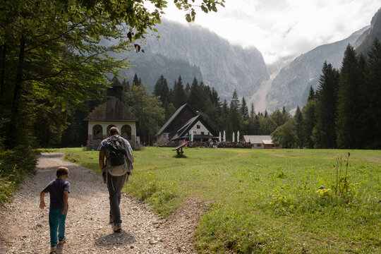 Father and Son Walking Along a trail to a Mountain Lodge in Slovenia