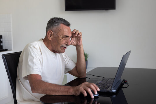 elderly senior man uses internet on laptop computer