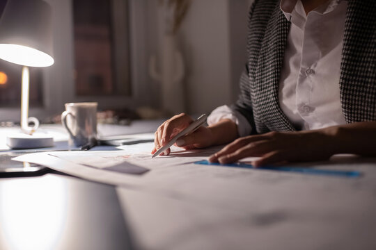 Cropped businesswoman checking notes at night