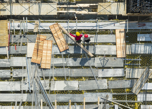 Aerial view of building construction and formwork with workers in hard hats in New Taipei, Taiwan.