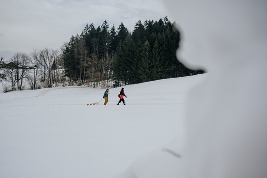 friends walking in distance across snowy field