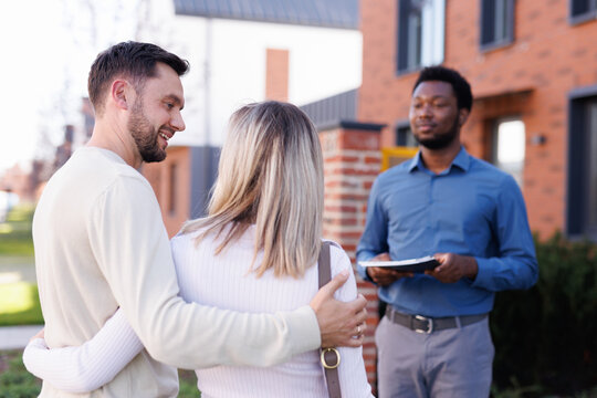 Man looking at wife and they listen realtor showing townhouse to them