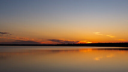 Obraz premium Sunset reflections on Riding Mountain National Park's Clear Lake,