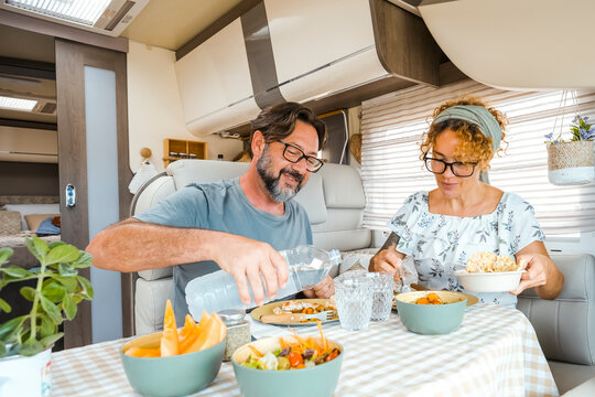 Couple enjoying a homemade meal together inside their motorhome during a relaxed road trip