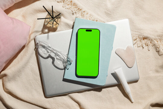 Flat lay of modern lifestyle items with a laptop, phone, cosmetic