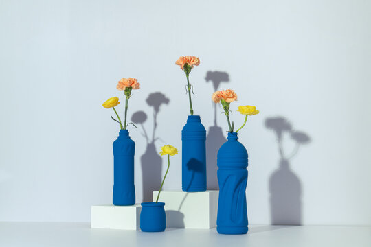 Blue painted bottles as vases with orange carnation