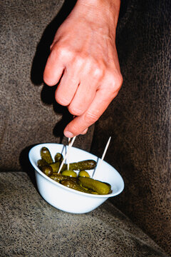 close-up of a man selecting an olive from a white bowl