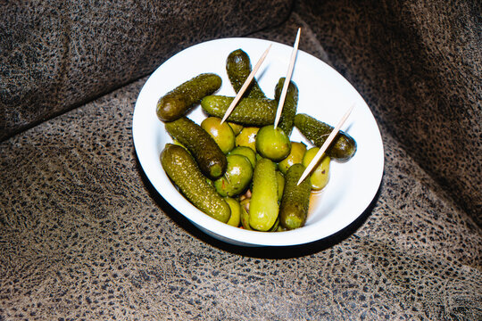 olives and pickled cucumbers in a white bowl