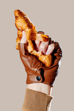 a man crushing a croissant in his gloved hand