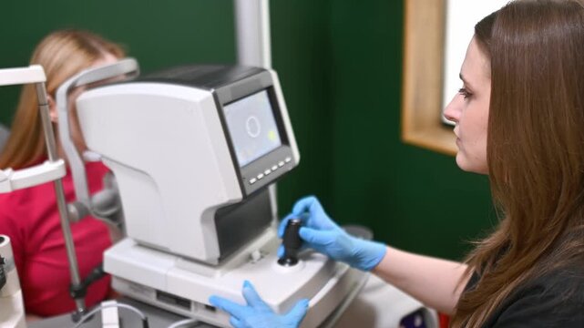 Examination of fundus of woman by ophthalmologist using retinal scanner. Patient during visit to optometrist for microscopic analysis of eyelids, sclera, conjunctiva, iris, lens, cornea. Eye exam