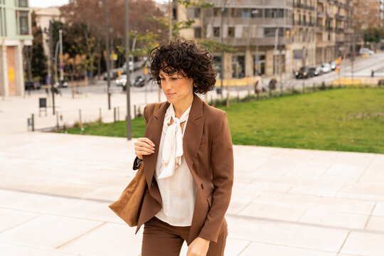Woman Walking in Business Attire on City Street in the Afternoon