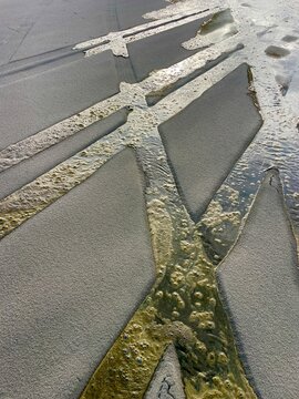 Water-filled tire tracks on beach