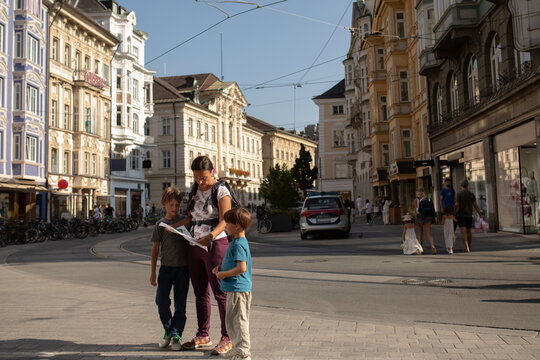 Family Explores City Streets of Innsbruck, Austria With a Map