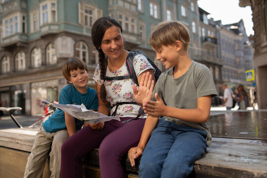 Family Enjoys Time Together in City Center While Looking at Map