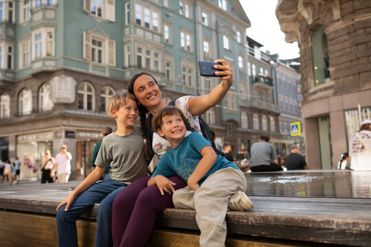 Woman and her Children Take a phone Selfie in Innsbruck, Austria