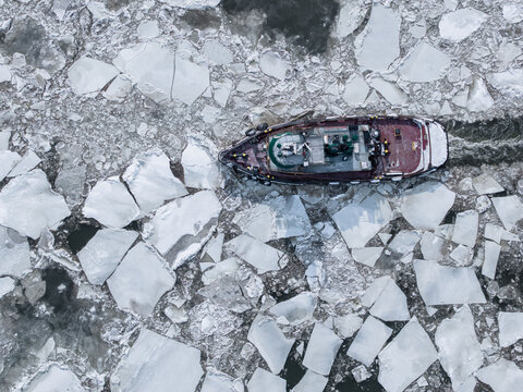 Boat Moves Through Ice in a Frozen Area During Winter Season