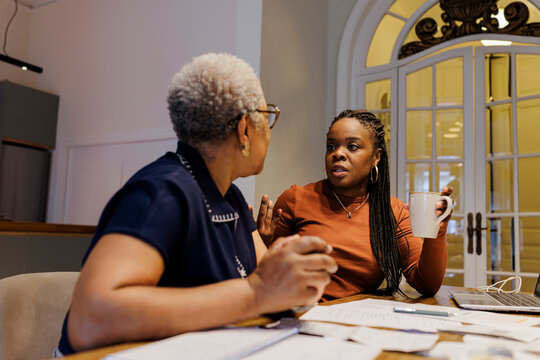 Women discussing finances and planning budget at living room