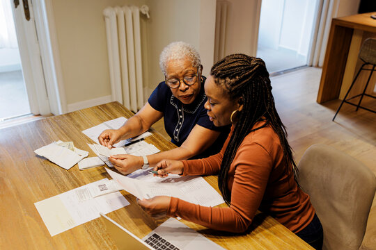 Women reviewing finances together, managing household budget