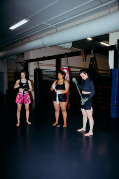 female boxers bandaging their wrists and hands