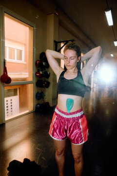 Female boxer fixes her hair in front of the mirror