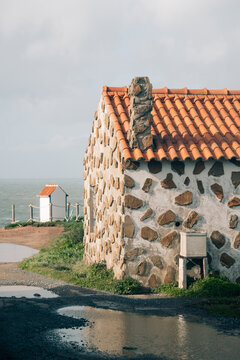 Old Stone House Near Water With Red Roof at Seaside Location