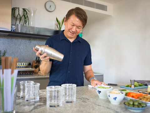 Man Prepares Cocktails in a Modern Kitchen With Fresh Ingredients