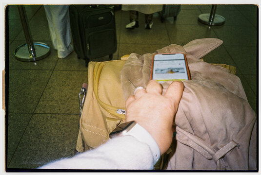Holding Phone While Waiting in Airport