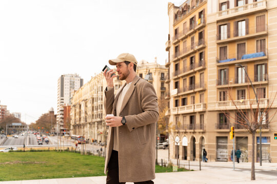 Man Walking With Coffee  and phone Outdoors