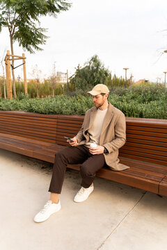 Man Using Phone On Bench