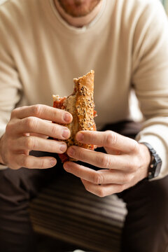 Person Enjoys Food While Seated Indoors in a Relaxed Setting