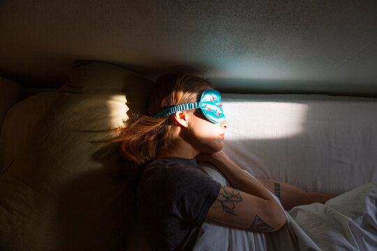 Woman sleeping soundly wearing eye mask in bed