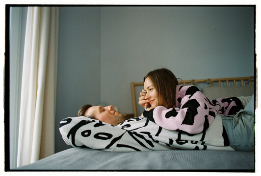 Romantic couple lying in bed looking into each other's eyes