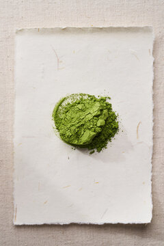 Matcha powder arranged in a neat circle on textured paper