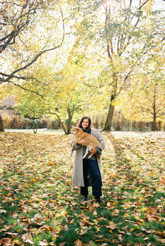 brunette woman hugging her shiba inu dog