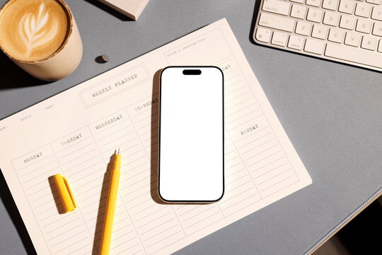 Phone mockup on business office desk with planner