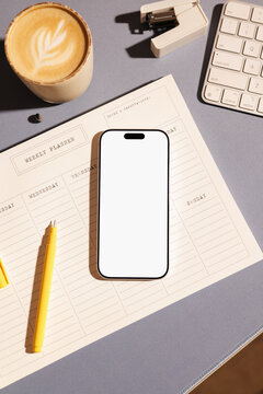 Business phone mockup with white screen on office desk