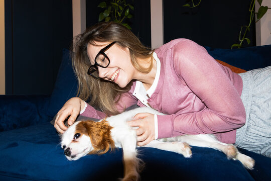 Woman Relaxing With Dog on Sofa at Home