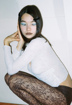 Model in a Light Sweater and Lace Tights Posing Indoors